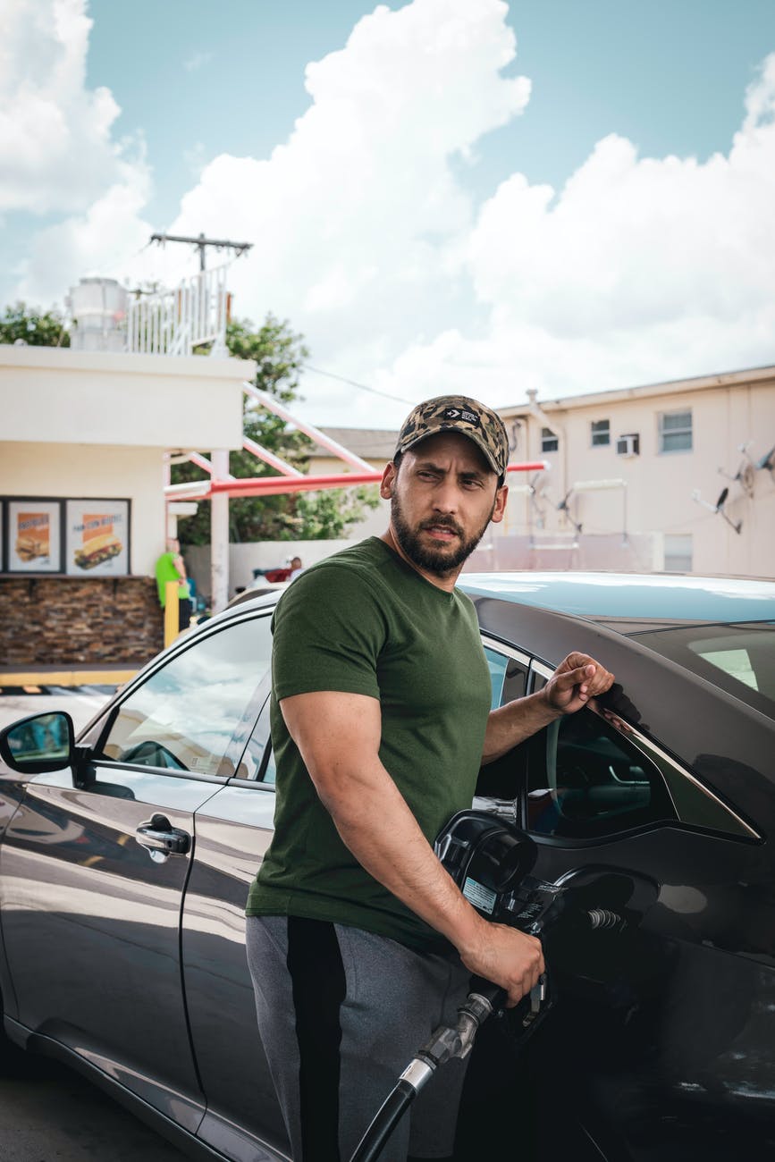 photo of a man fueling up his car